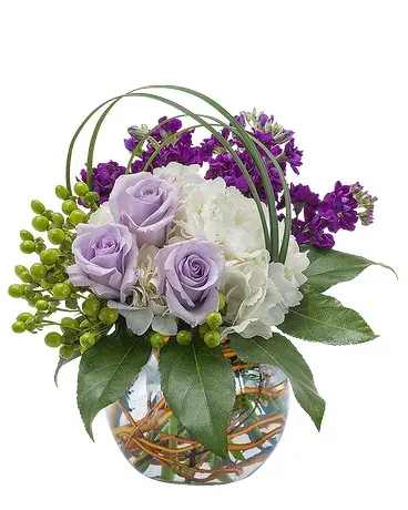 Lavender roses and white hydrangea in a glass vase with purple flowers