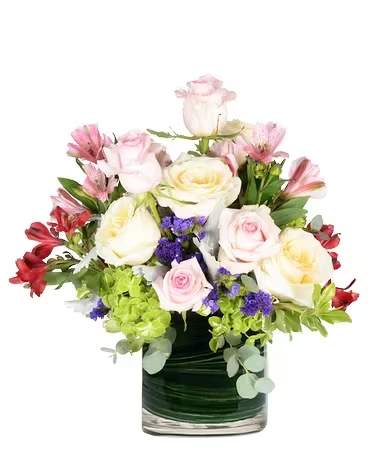 Mixed pink and white roses in a glass vase with purple accents