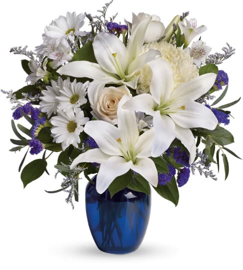 Shocking Blue - In this arrangement the serenity of the color blue along with the purity of intention symbolized by white will let the family know you are sending your calm strength to them during these difficult times. Beautiful blooms such as crème roses white lilies and alstroemerias, daisies along with white chrysanthemums, limonium and more are beautifully arranged in a dazzling cobalt blue vase. Approximately 16 1/2" W x 18" H Orientation: One-Sided As sqhown: DGT2093A