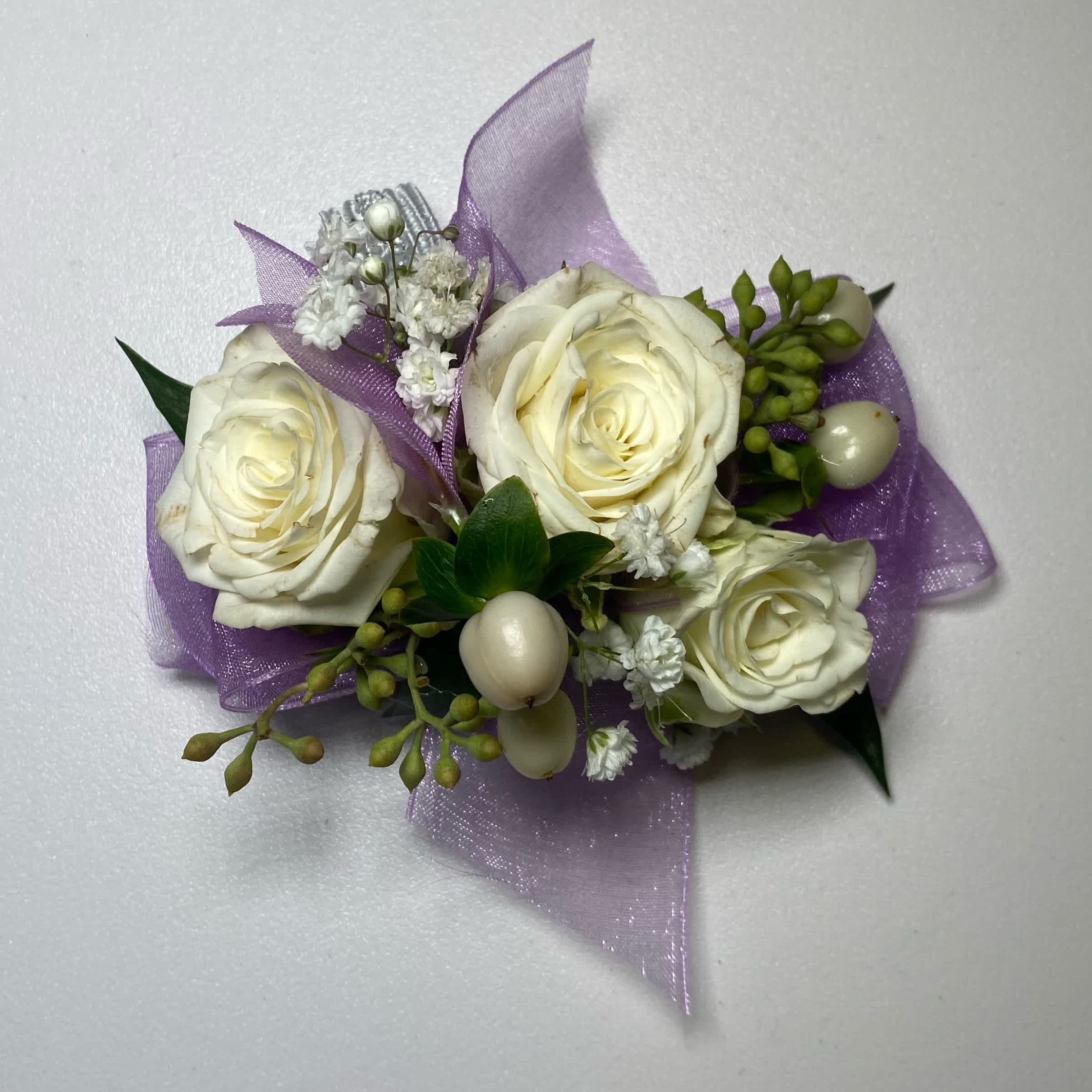 Small corsage with white roses and purple ribbon