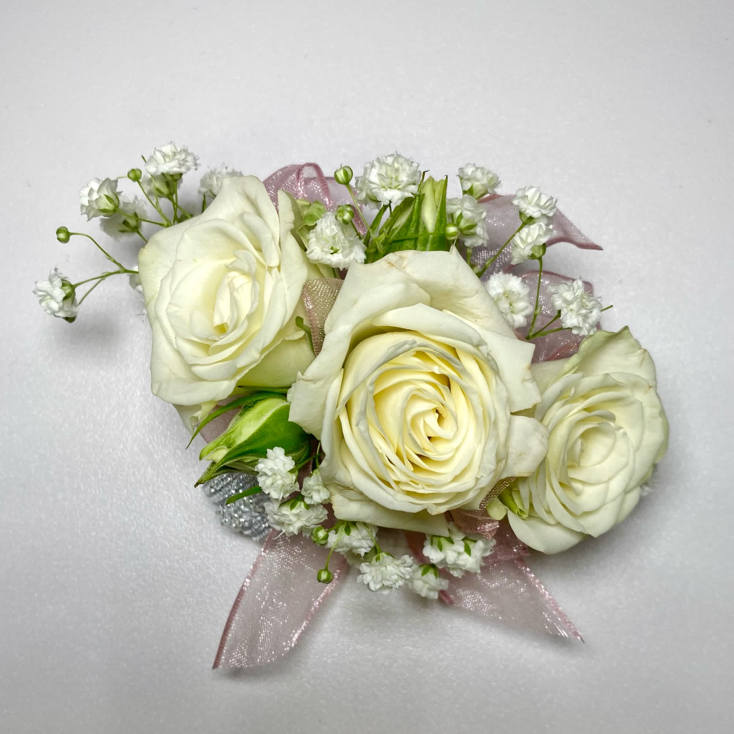 White rose corsage with baby's breath and pink ribbon