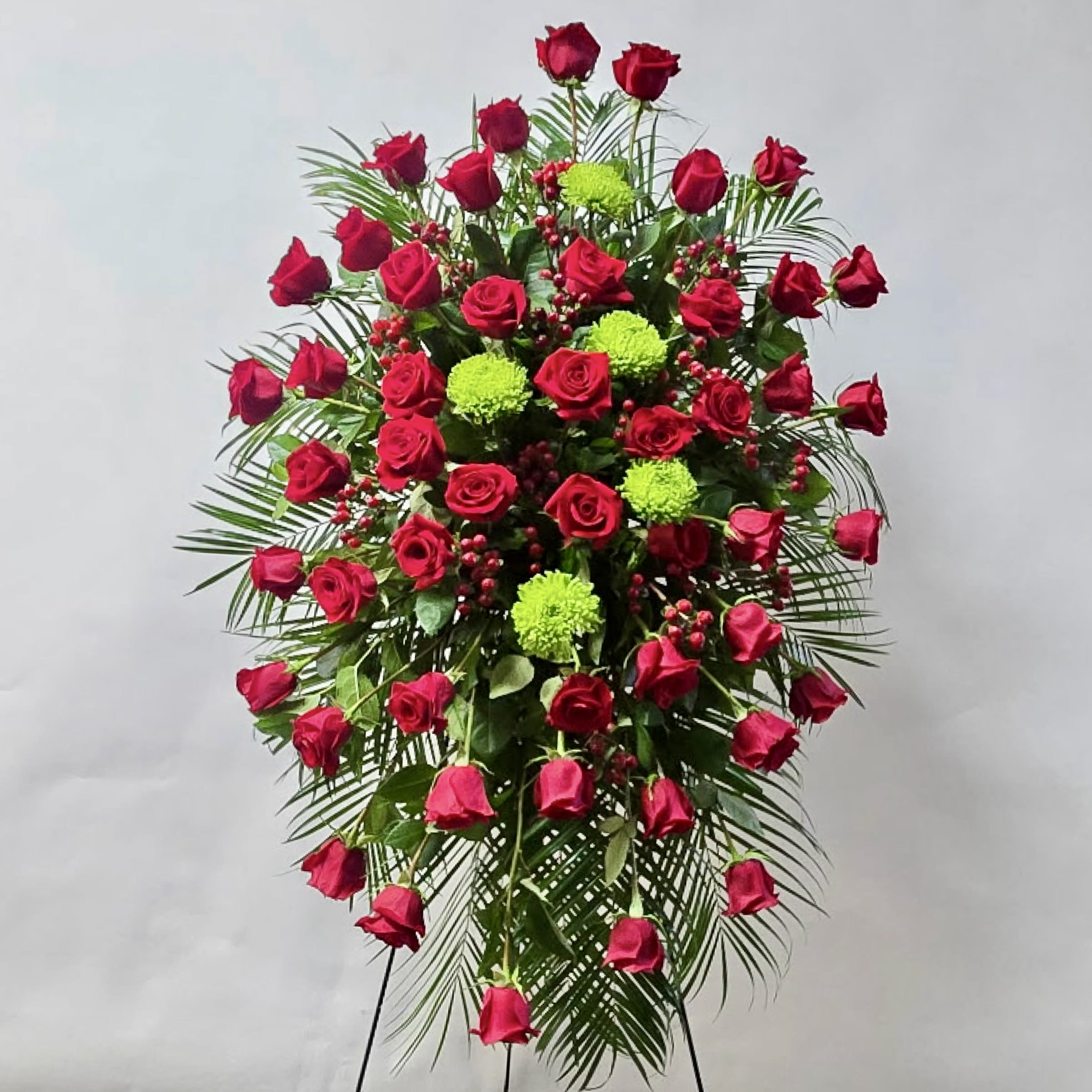 Standing spray of red roses with green pompons and palm fronds