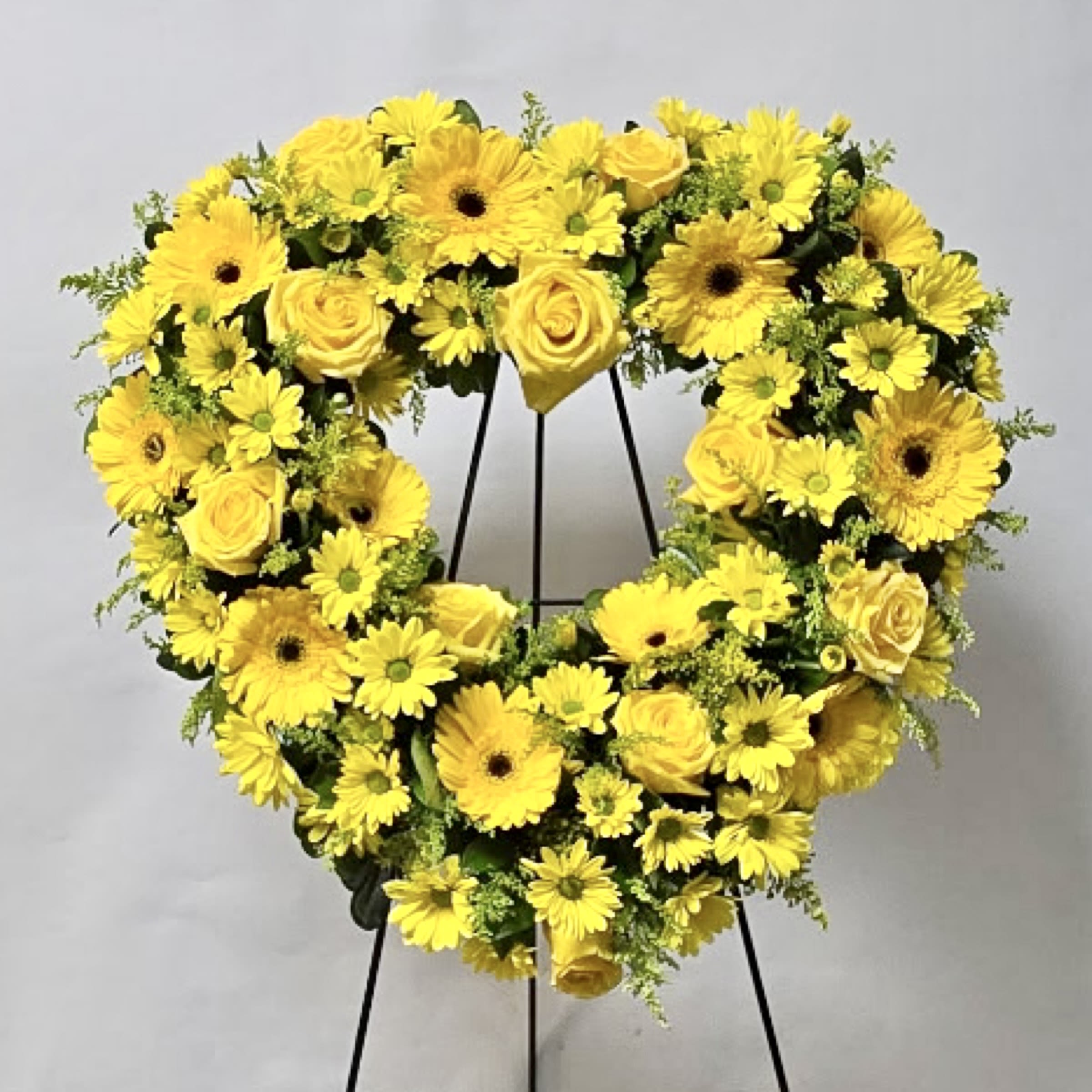 Yellow flower wreath on a black stand