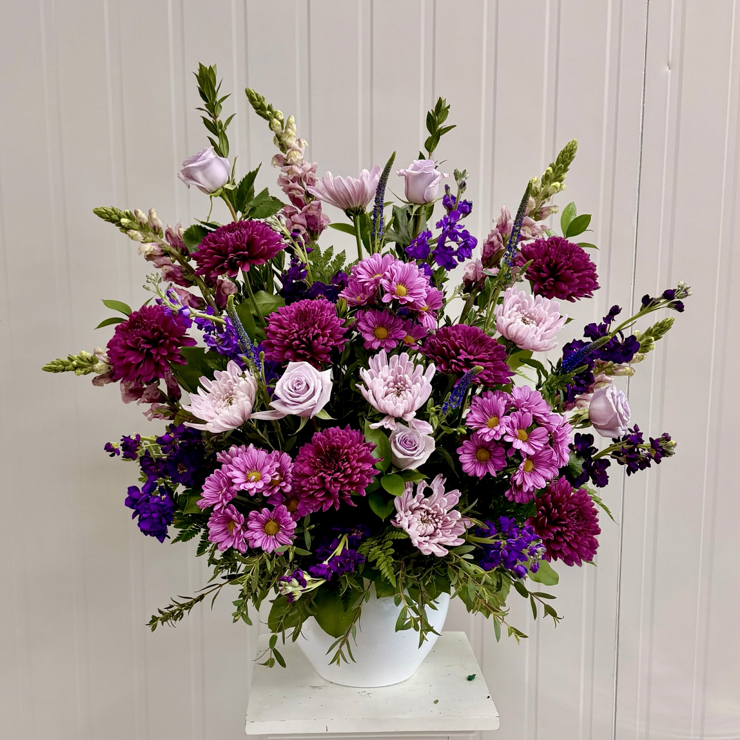Designers Choice Purples and Lavender Side Piece  - A Designers Choice Assortment of Fresh Cut Flowers Arranged in a Mortuary Approved Plastic Container. A Custom Purple Arrangement Hand Selected by the Designer. We Design this Arrangement Differently every time with the Freshest Blooms Available.