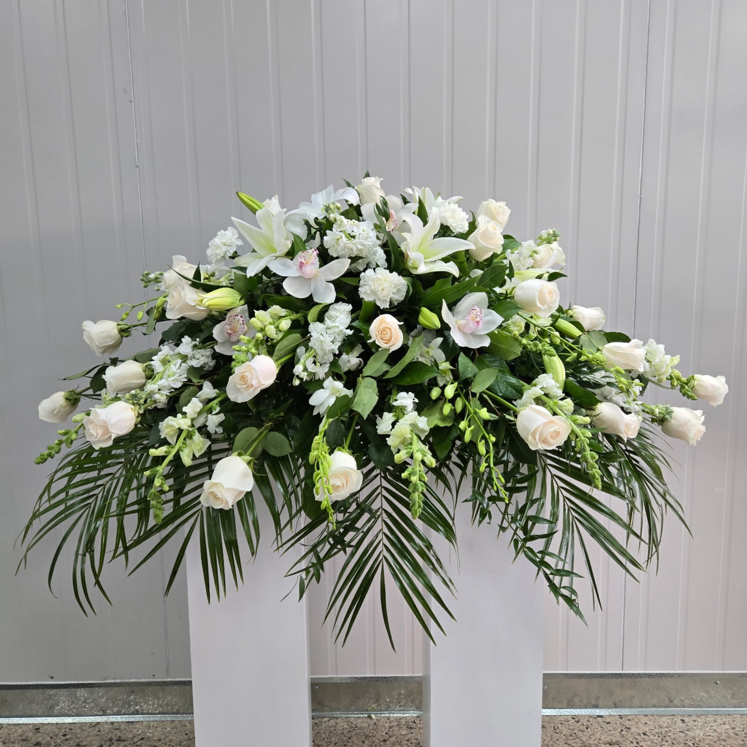 All White Casket Spray - This Casket Spray includes White Roses, White Dendrobium Orchids, White Cymbidium Orchids, White Stock, White Snapdragon, and White Lily. Or as Similar as Possible. 