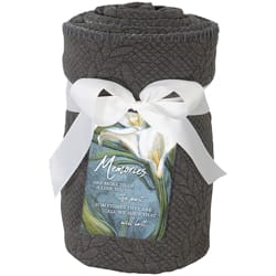 Dark woven gift basket tied with a white ribbon and a floral label