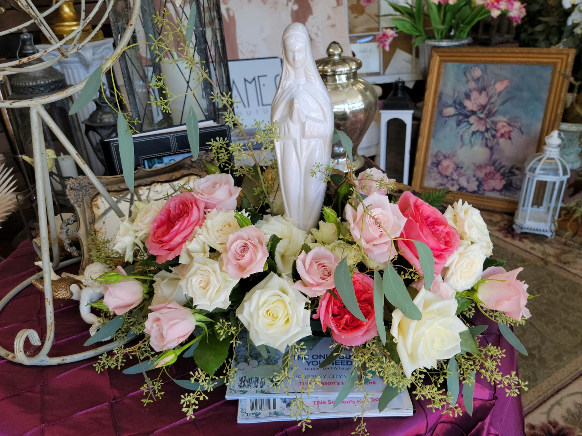 Pink and white roses arranged around a white statue