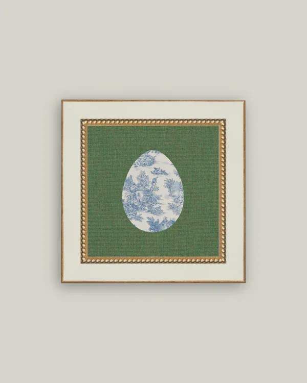 Framed decorative print with a blue-and-white egg motif on green fabric