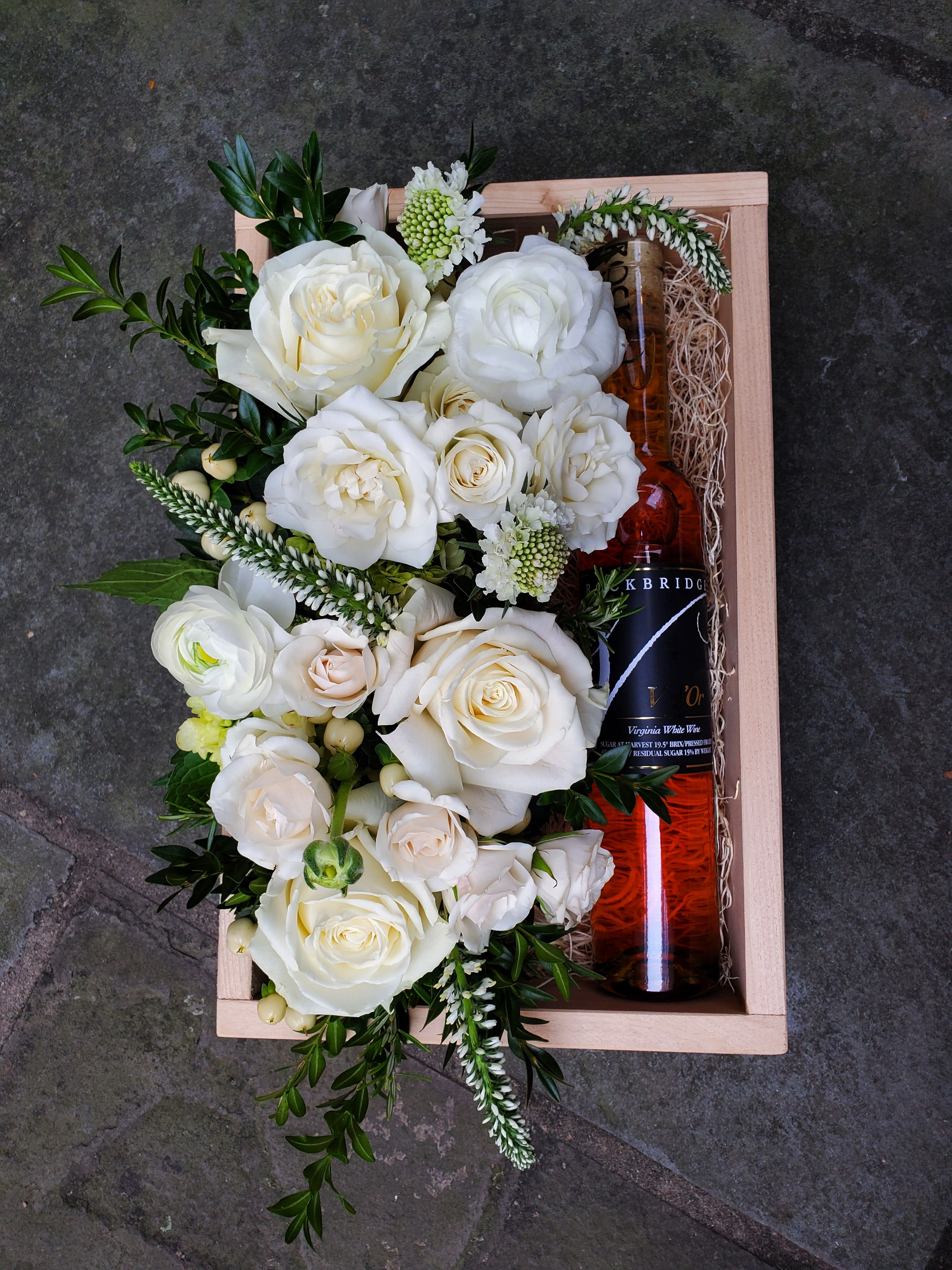 Dessert Wine Gift Box - A beautiful wooden gift box, locally hand-crafted from reclaimed wood. A bottle of Rockbridge Vineyard V D'or Dessert Wine rests on a bed of Spanish moss, alongside a beautiful bed of flowers in the pavé style. You may specify a color for this arrangement if desired.  Wine Description: This multi-award-winning dessert wine is made in the style of ice wine, where grapes are intentionally frozen on the vine to enhance their sweetness.  With notes of honey and orange, this elegant gift-worthy bottle is sure to delight any wine lover.  Before placing your order, please ensure that the recipient is above 21 years of age and will be home to receive the delivery, as ABC regulation requires that we check photo ID upon delivery. If no one is present at the delivery site, delivery cannot be completed.  Box measures 8.5x11.5".