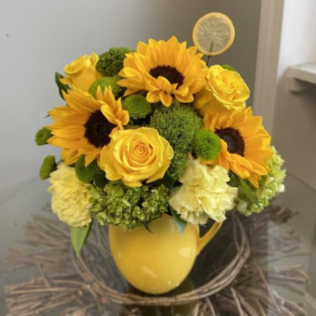 Yellow sunflower and rose arrangement in a yellow mug vase
