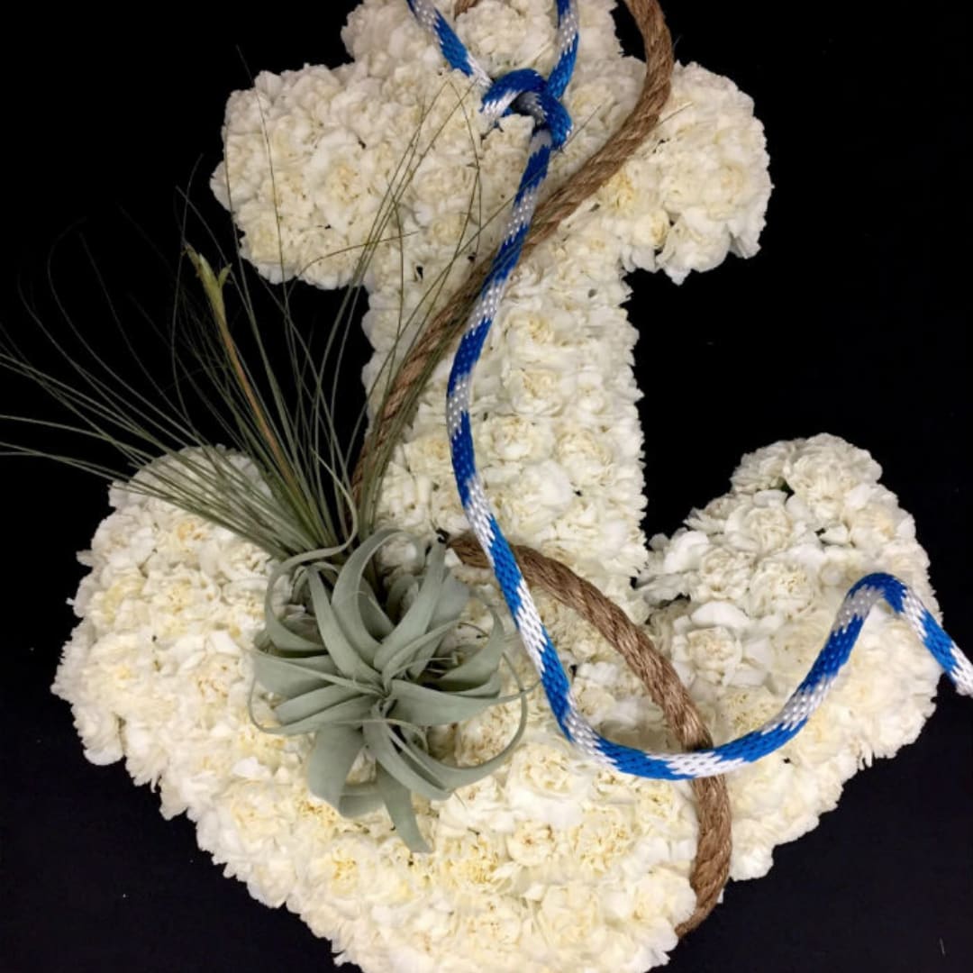 White floral cross with rope and blue cord accents on a black background
