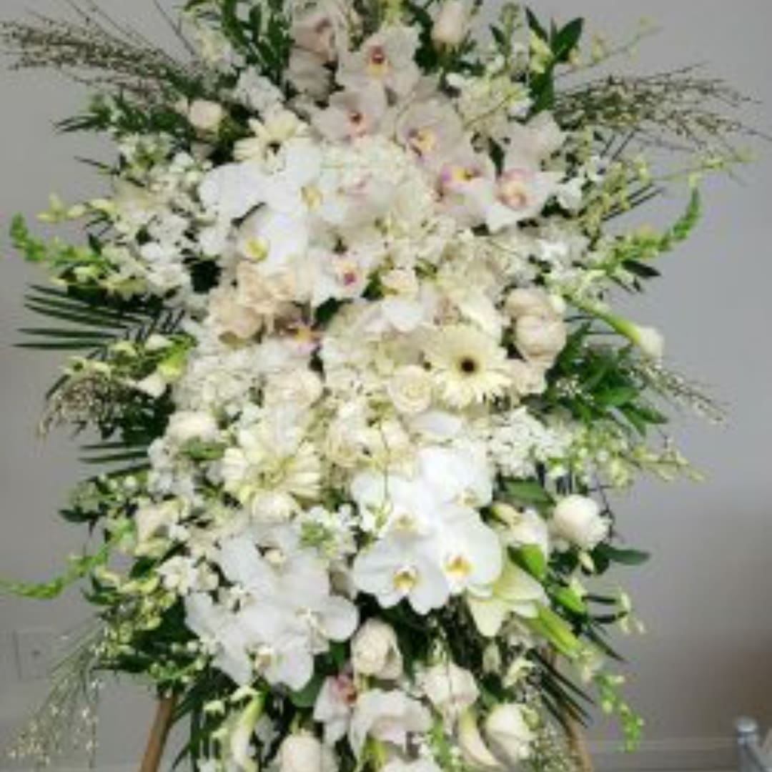 Large white floral standing arrangement with orchids and lilies