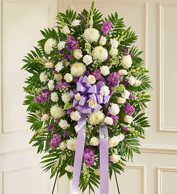 Standing floral spray with white and purple flowers and a lavender ribbon