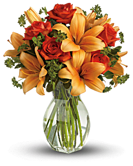 Orange lilies and red roses in a clear glass vase