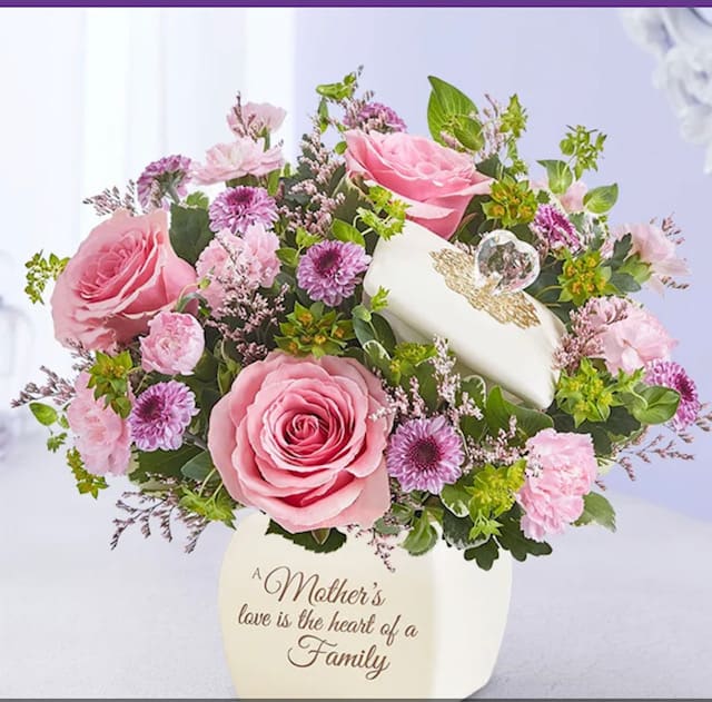 Pink roses and purple mums in a cream keepsake vase with a lidded trinket box.