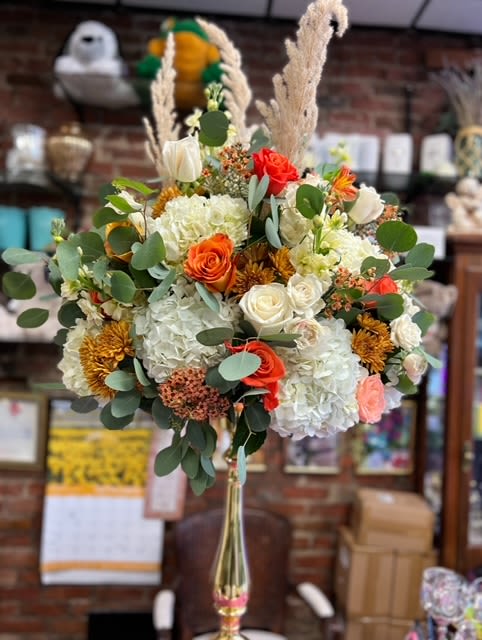Stunning Autumn Luxe Floral Arrangement – Available for Flower Delivery in Amityville - Capture the warmth and elegance of the season with this luxurious fall-inspired arrangement from Heavenly Flowers Too, your go-to Amityville florist. Perfect for weddings, events, or as a stunning décor piece, this tall arrangement exudes sophistication and charm.  This design features an opulent combination of white hydrangeas and ivory roses, creating a soft, neutral base that contrasts beautifully with the vibrant pops of burnt orange roses and golden mums. Accents of peach hypericum berries and eucalyptus greenery add texture and depth, while dramatic pampas grass provides a whimsical, airy touch that elevates this arrangement into a true statement piece.  Arranged in an elegant, tall gold vase, this design is ideal for creating a focal point at any event or home. The balance of lush florals and seasonal textures makes it perfect for those seeking a centerpiece that blends classic beauty with contemporary style.  Order this breathtaking arrangement today at heavenlyflowerstoo.com to enjoy same-day flower delivery in Amityville. Whether you're hosting an autumn gathering or looking for the perfect floral gift, Heavenly Flowers Too ensures every arrangement is crafted with care and creativity to bring your vision to life.  Trust our expert florists to deliver beauty, quality, and joy—right to your doorstep. Let this fall-inspired arrangement be the highlight of your décor or gift-giving experience.