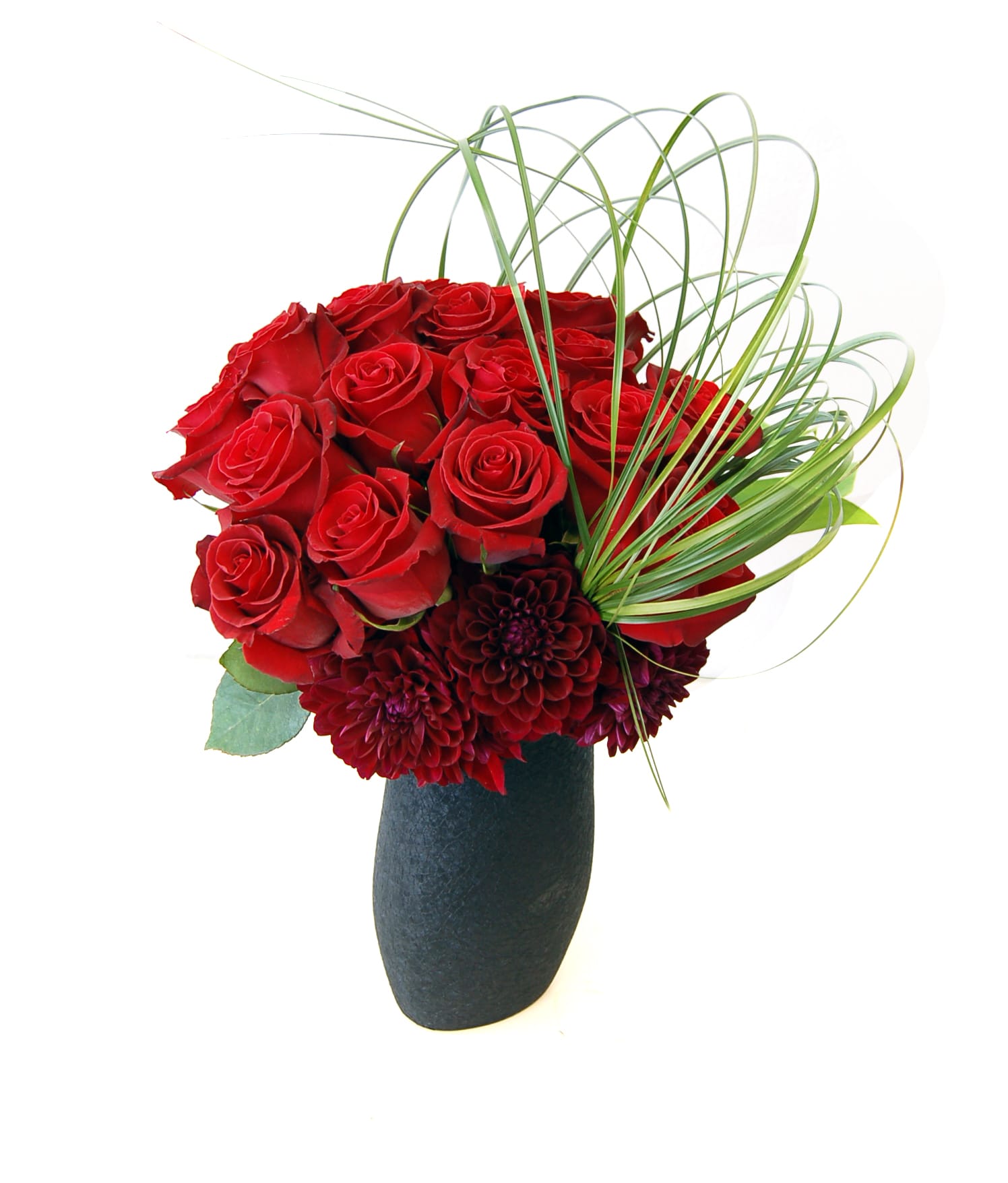 Aurora - Approx. 15" tall available in red roses as a standard but we can customize it to different colored roses (please note in the special instructions section and we will try to accommodate as best we can) and Dahlias accent with Steel Grass arches In a unique black vase.