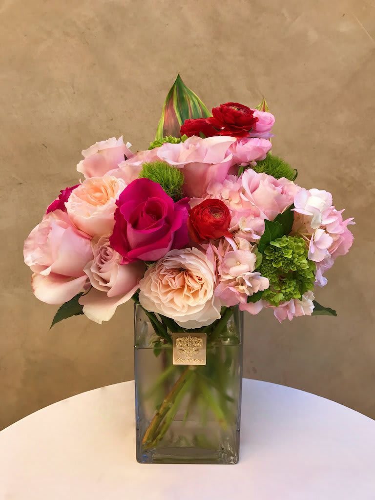 Pink and red rose bouquet in a square glass vase