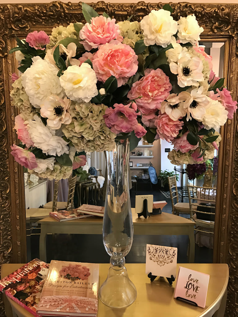 Large pink and white floral arrangement in a tall glass vase