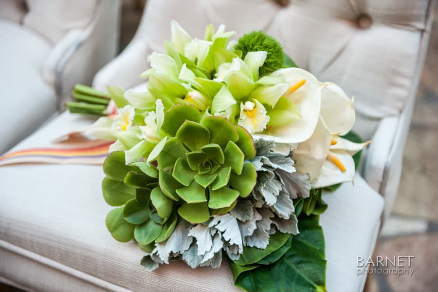 Bouquet of white calla lilies and green succulents with silver foliage