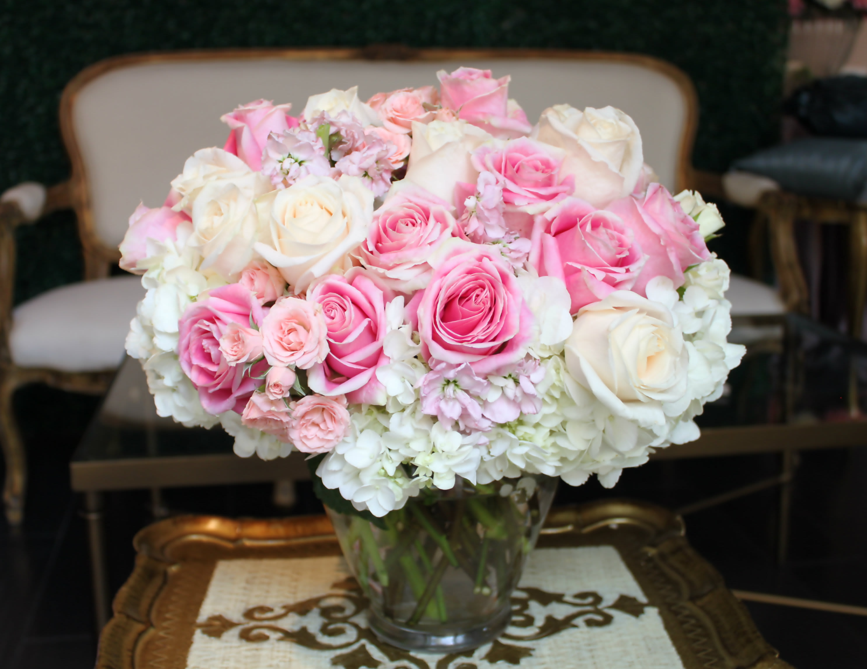 Pink and white roses arranged in a clear glass vase