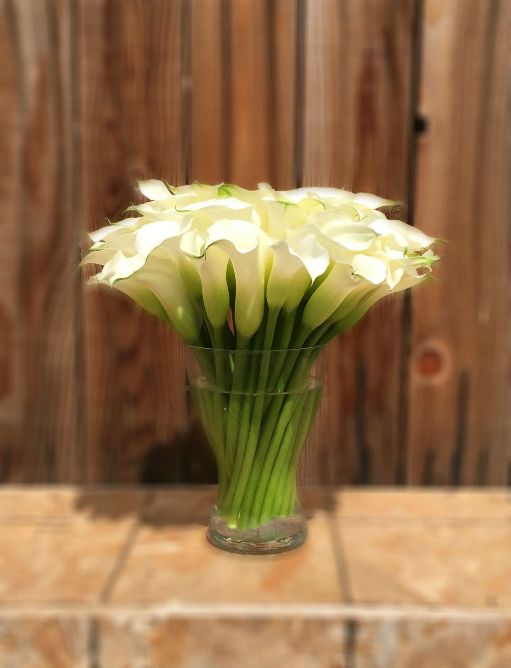 White calla lilies arranged in a clear glass vase