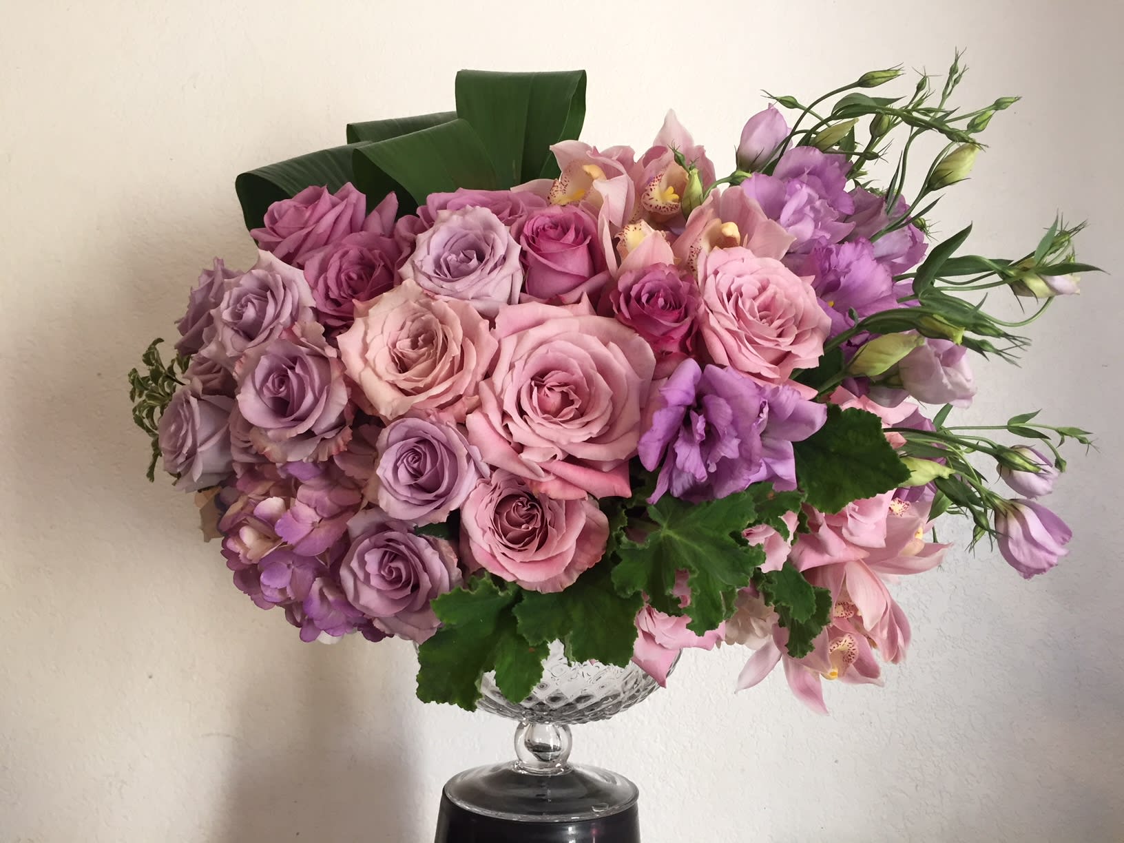 Pink and lavender rose bouquet in a clear glass vase