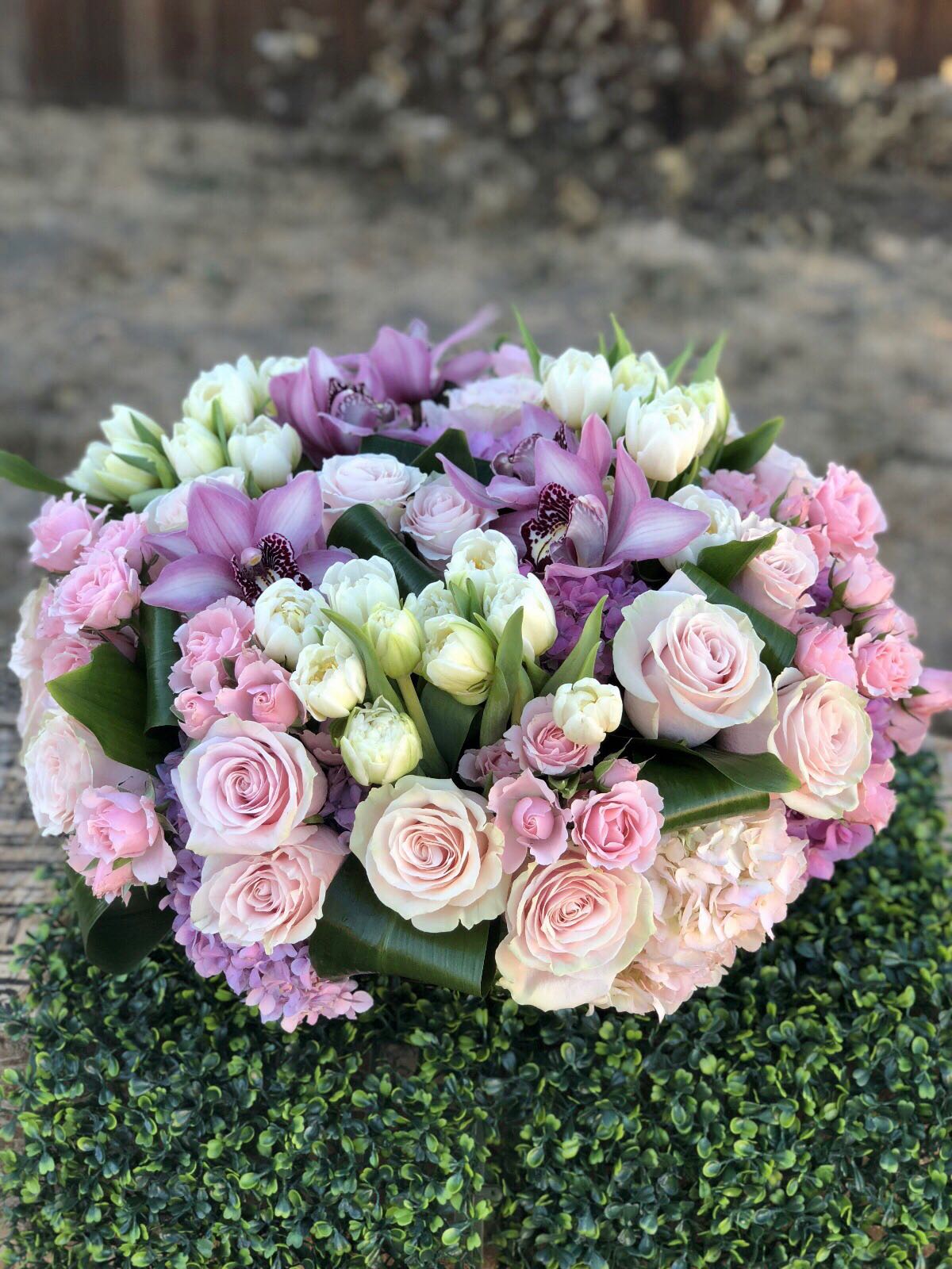 Pink and white bouquet with roses, tulips, and orchids