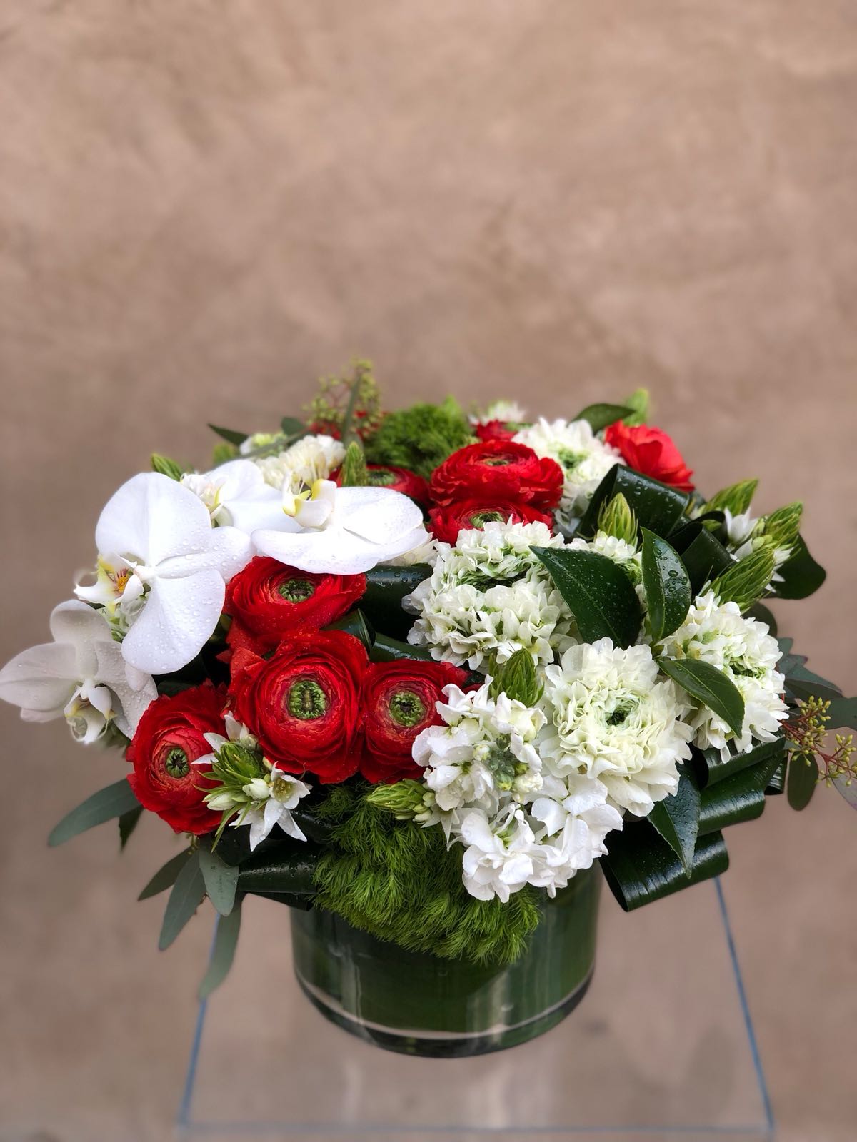 Red and white floral arrangement in a green vase