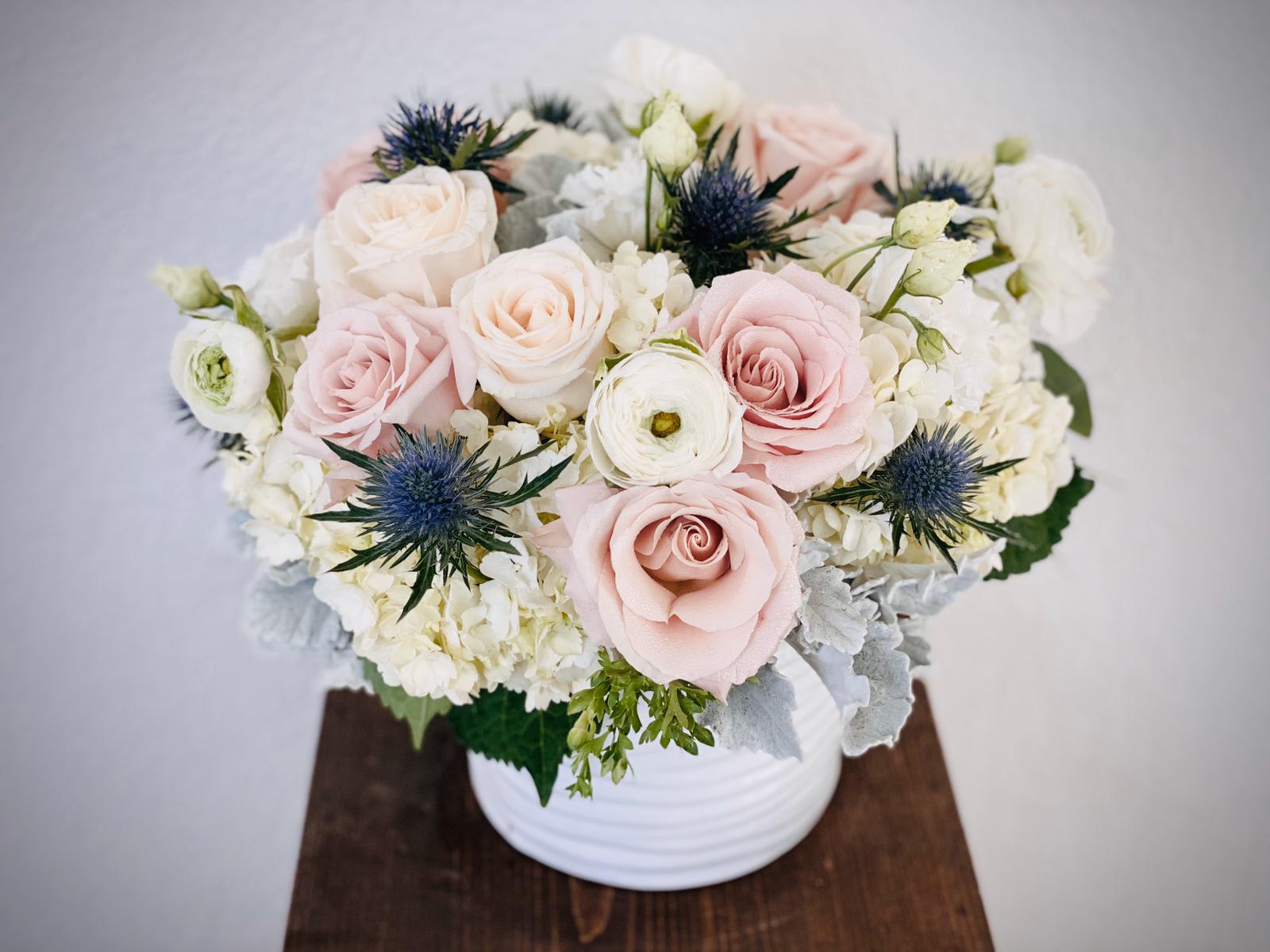 Blush and white rose arrangement in a white vase