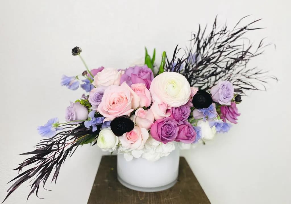 Bouquet of pink and purple roses in a white vase