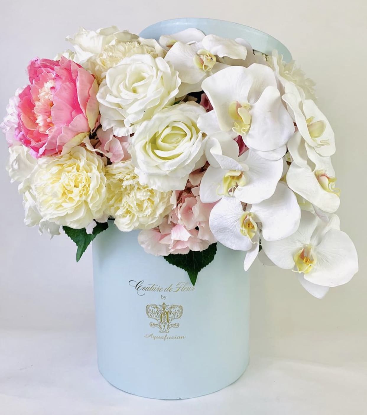 Pink and white flowers arranged in a pale blue hat box