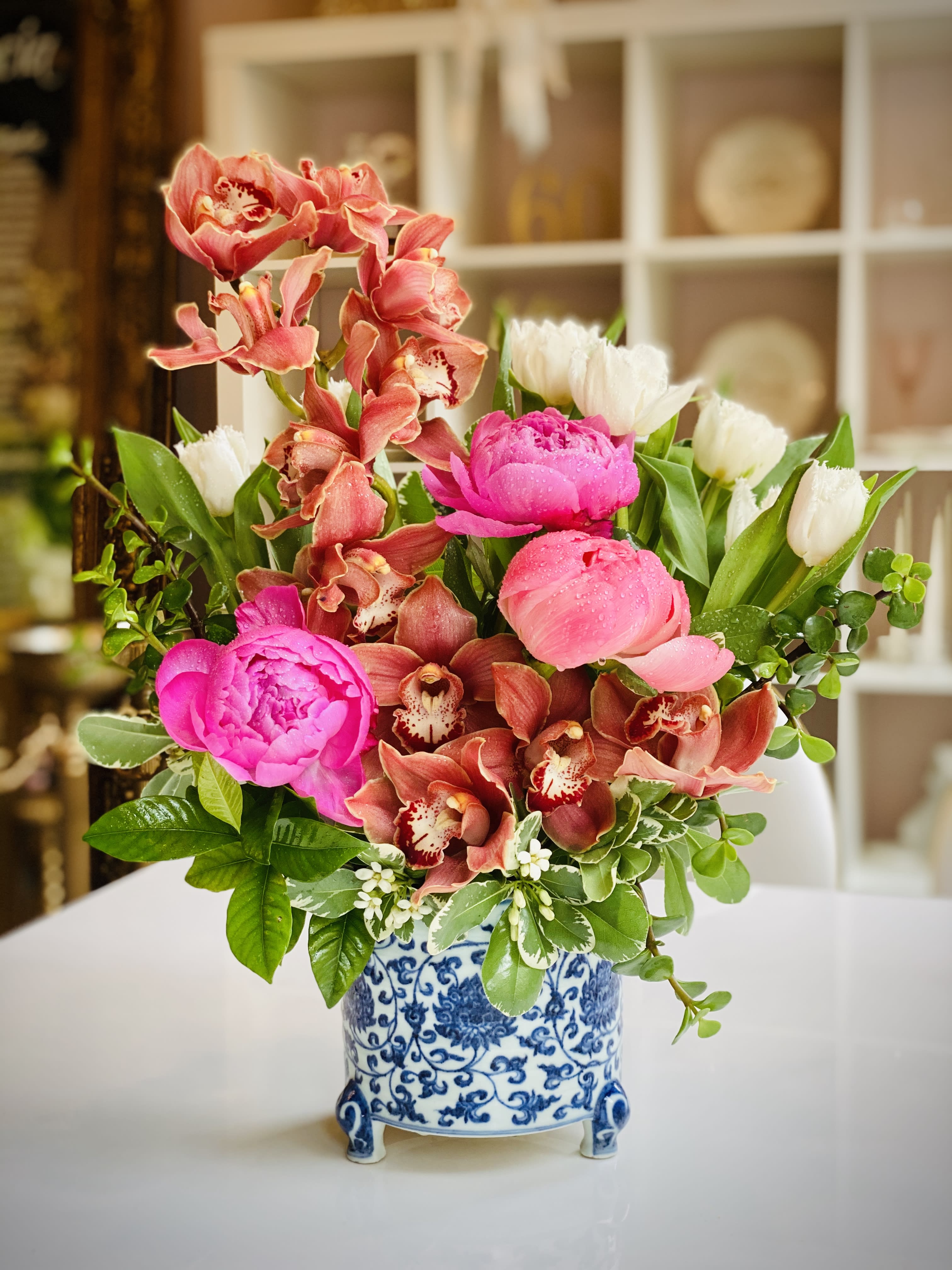 Pink peonies and orchids in a blue-and-white ceramic vase