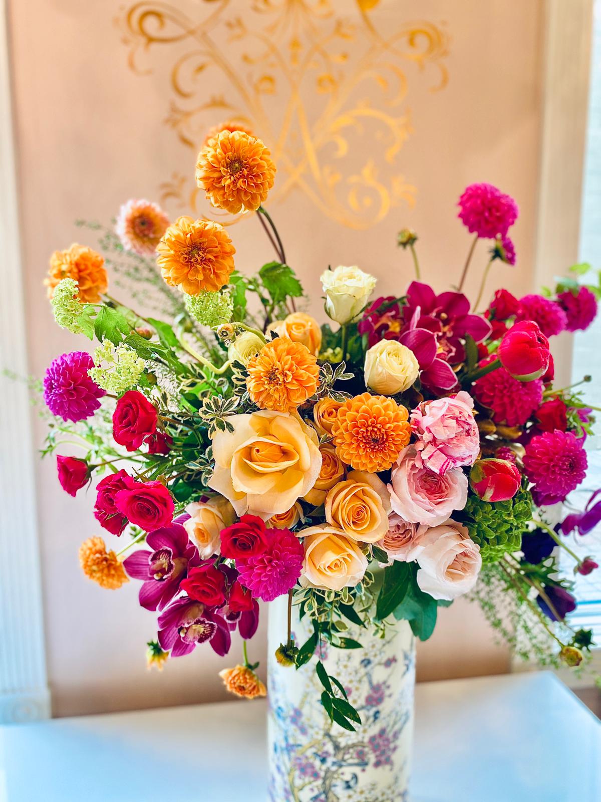 Colorful bouquet of roses, dahlias, and orchids in a floral vase