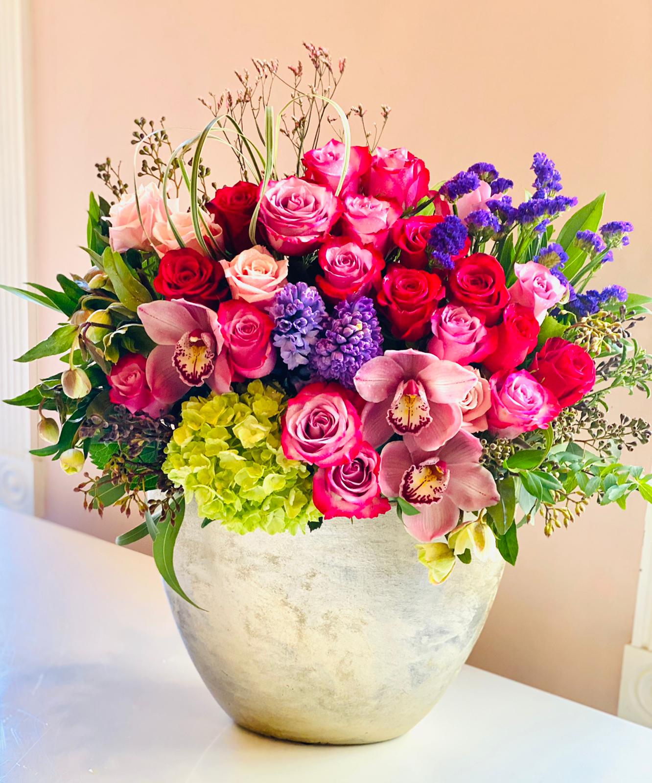 Mixed pink and purple floral arrangement in a silver vase