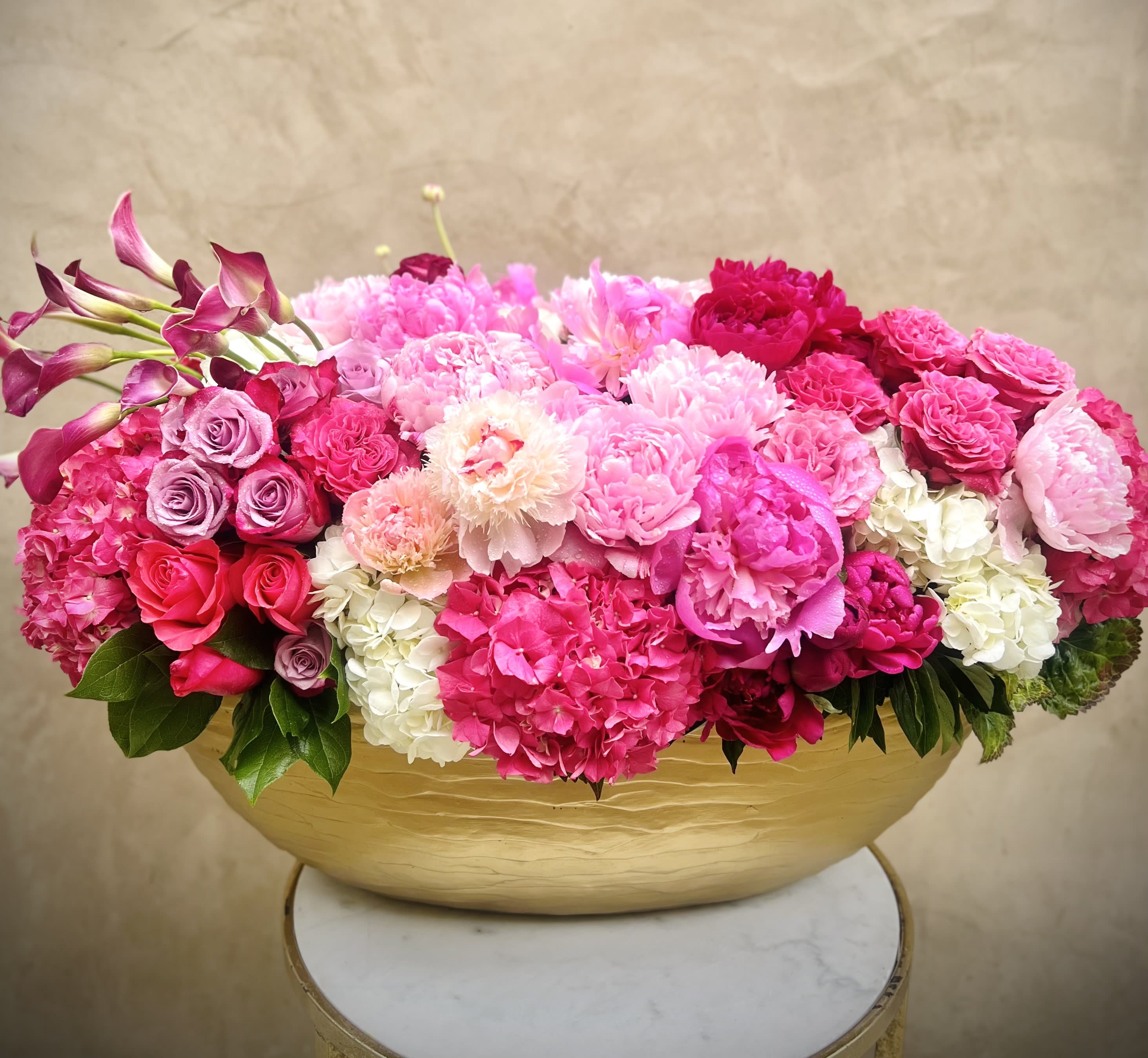 Pink and white floral arrangement in a gold bowl vase