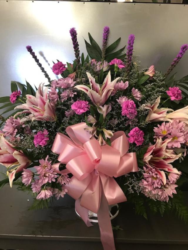 Pink and white floral spray with a large pink ribbon