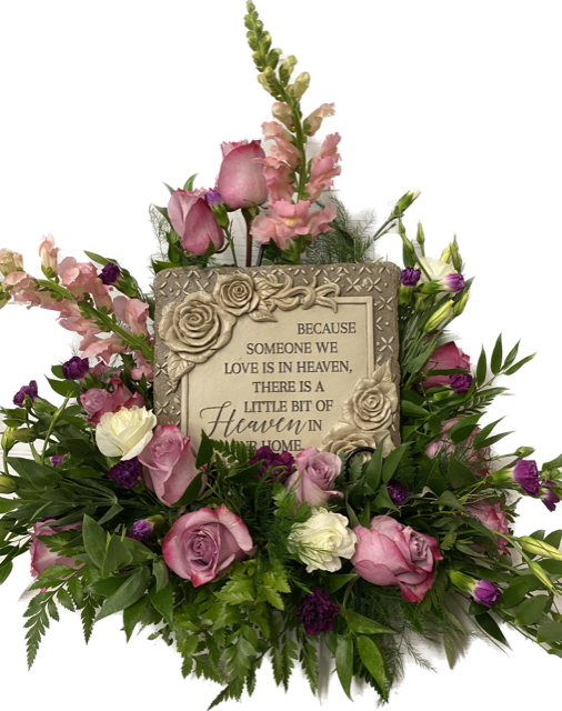 Pink and white roses surround a memorial plaque with a heaven message.