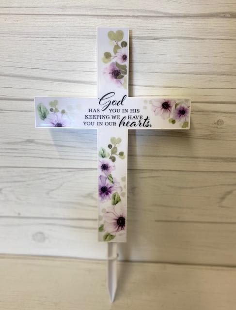 Floral cross sign with a sympathy message on a stake