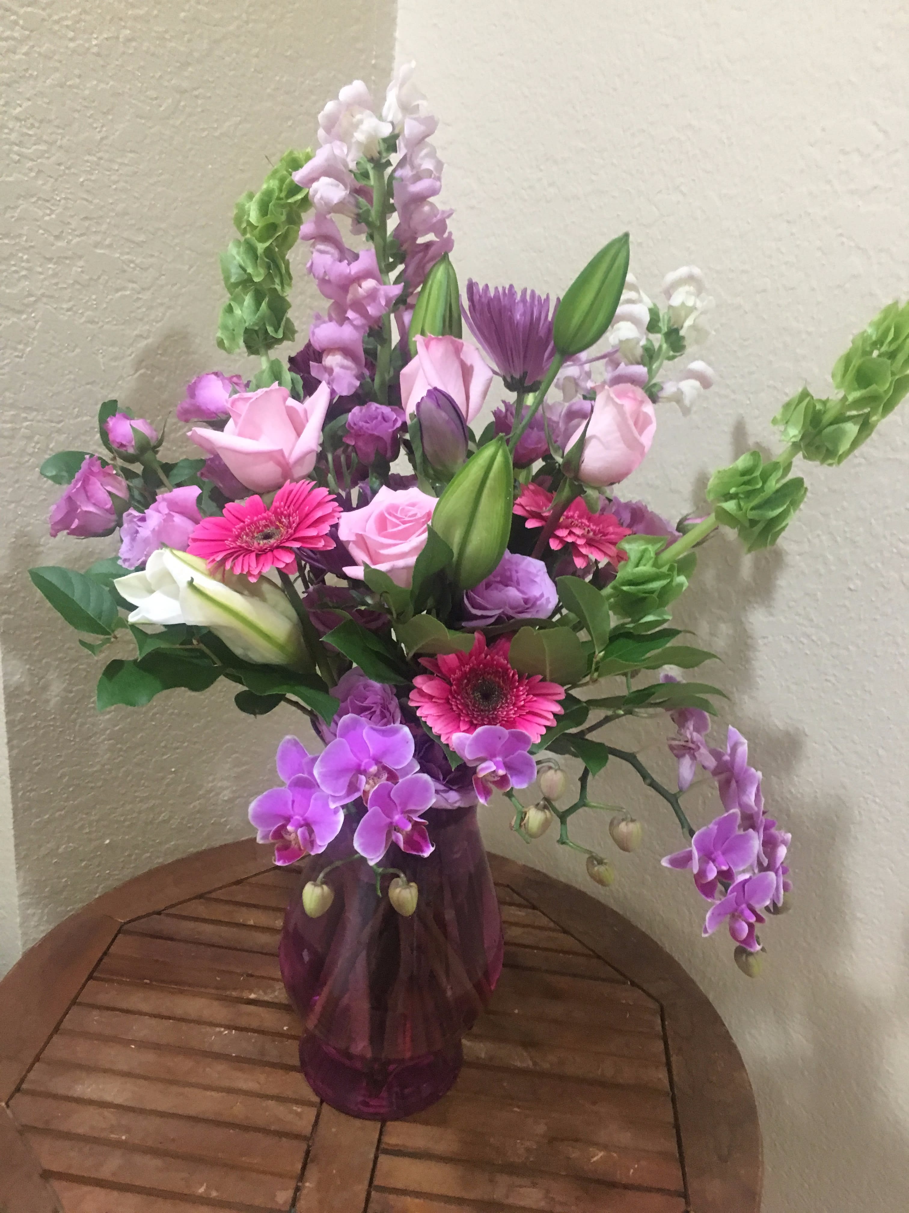 Bouquet of pink and purple flowers in a purple glass vase