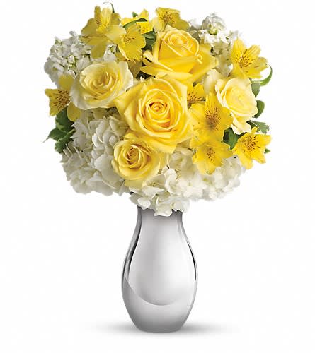Yellow roses and white flowers in a silver vase