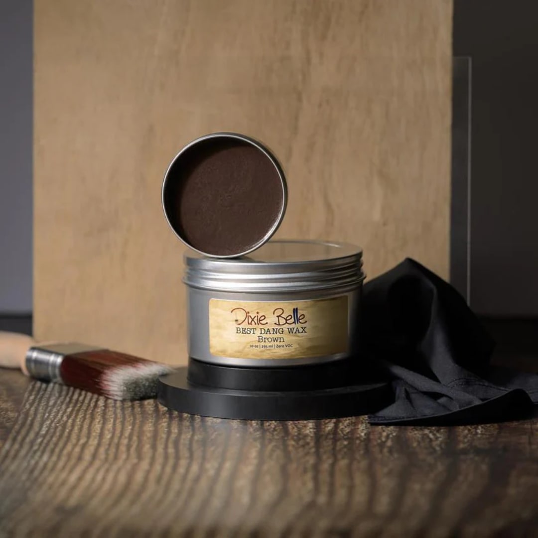 Tin of brown wax with lid propped open on a table