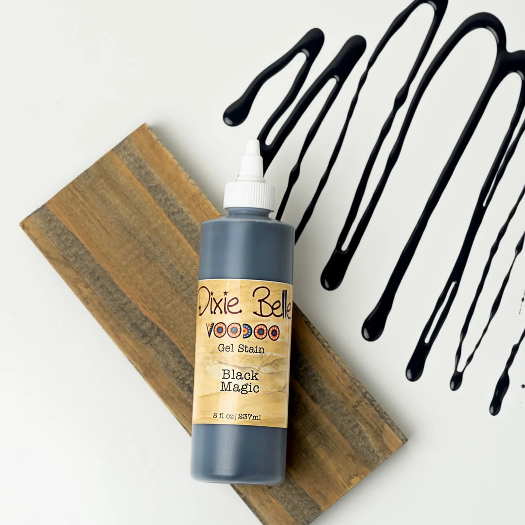 Bottle of black gel stain on a wood board with black drips nearby
