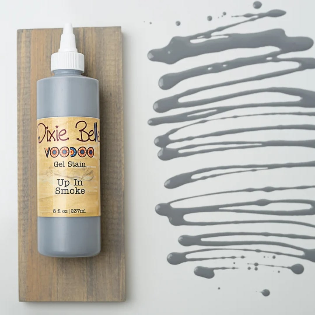 Bottle of gray gel stain on a wood board beside gray paint swatches