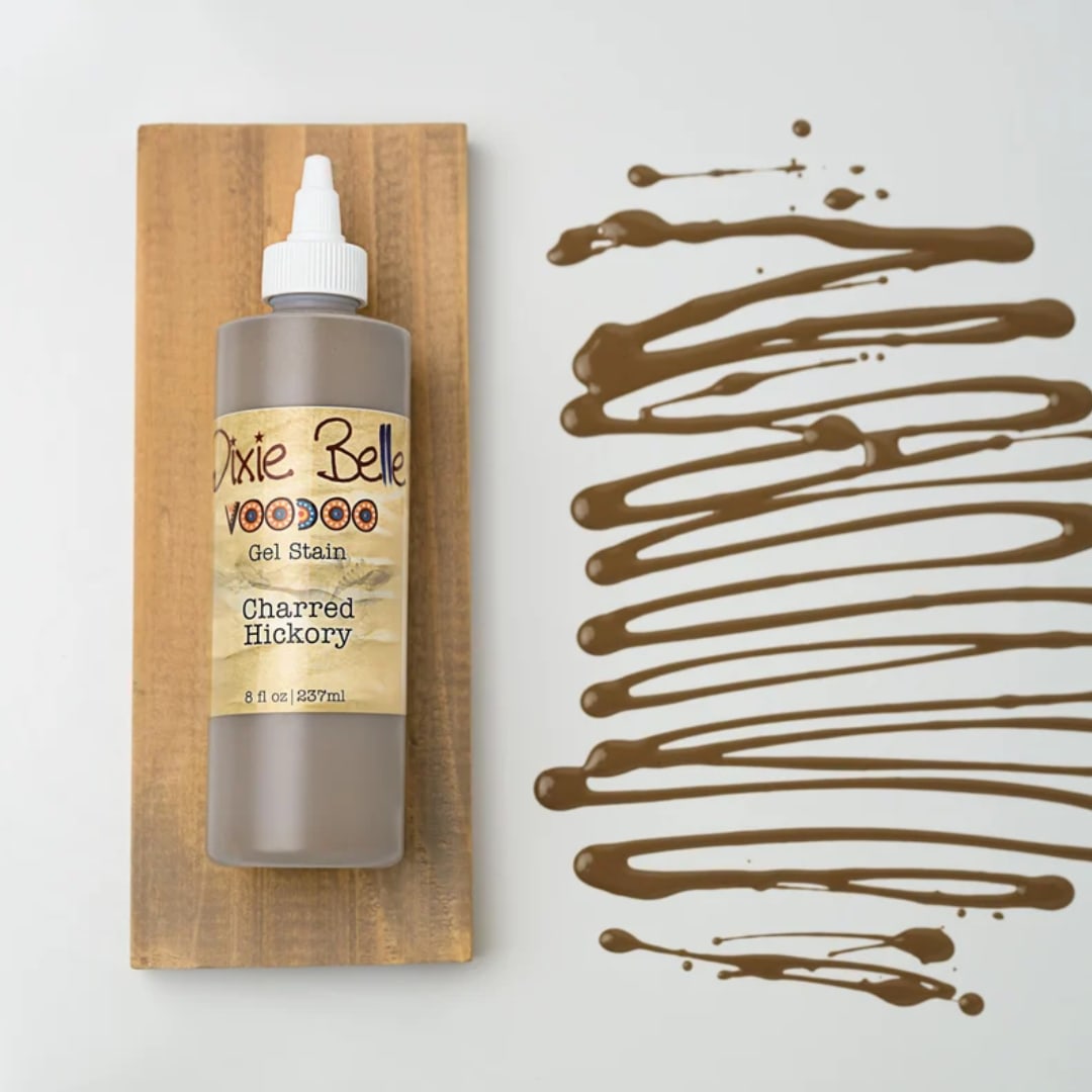 Bottle of wood stain on a wooden board beside brown paint swatches