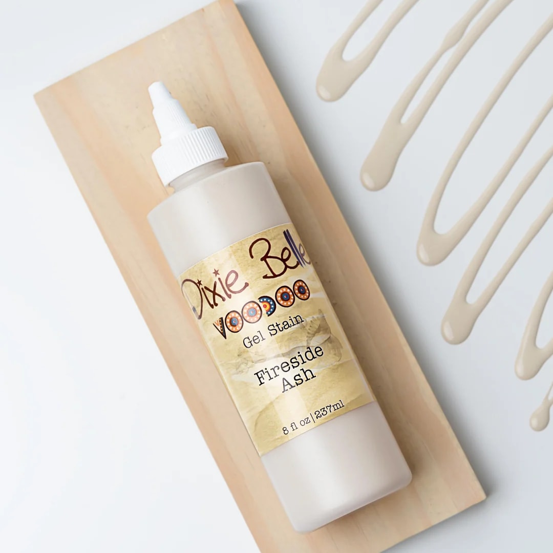 Bottle of Dixie Belle gel stain on a wooden board with paint swatches