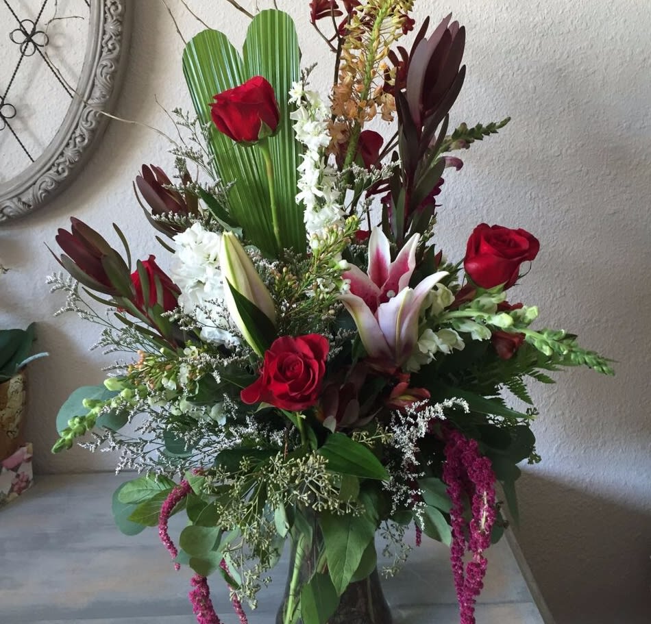 Sweetheart  - This arrangement offers a whimsical take on the classic red rose arrangement. Lovely roses accented by pink lilies, arranged among green accents. (one side look)