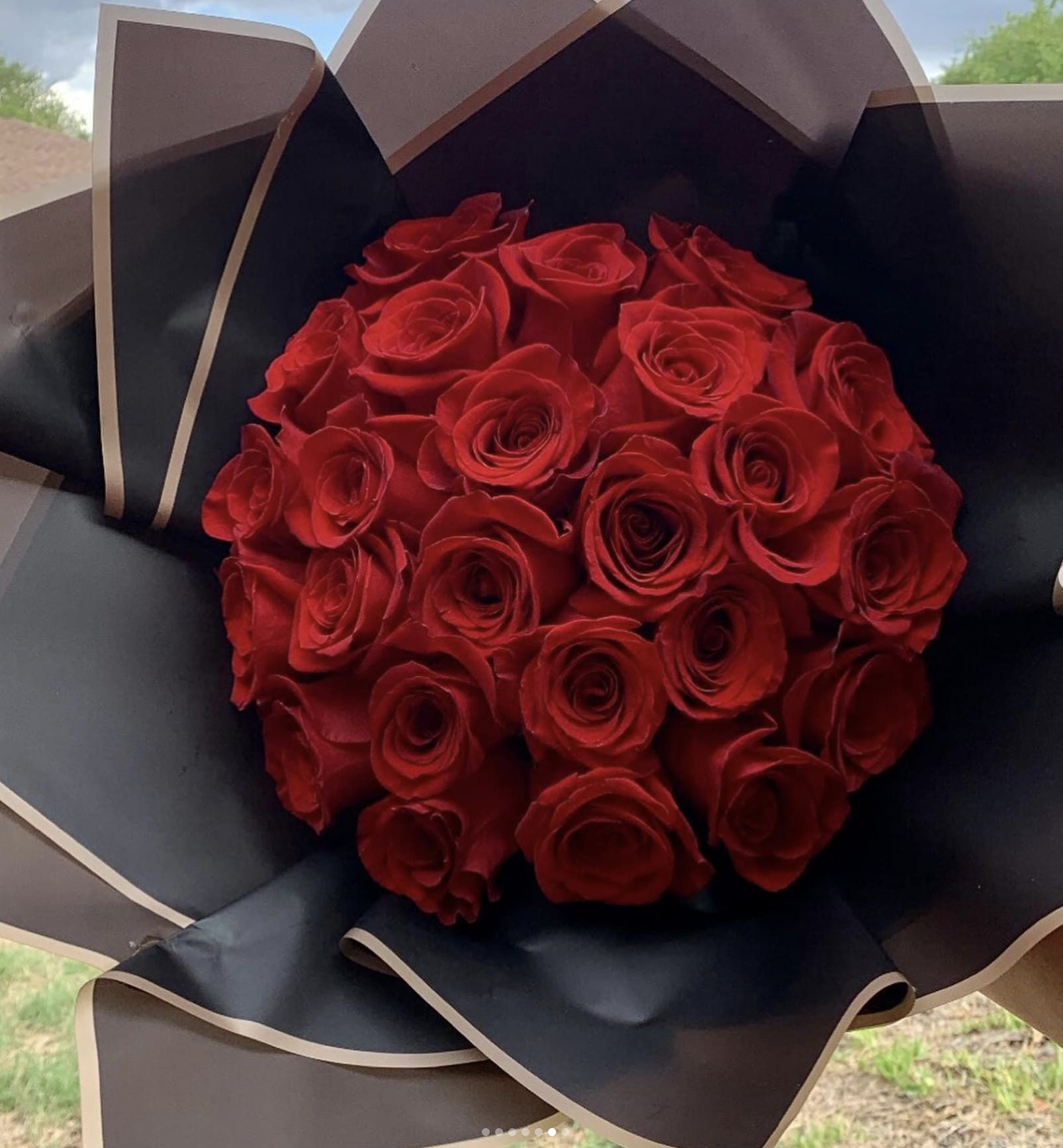 Bouquet of red roses wrapped in black paper