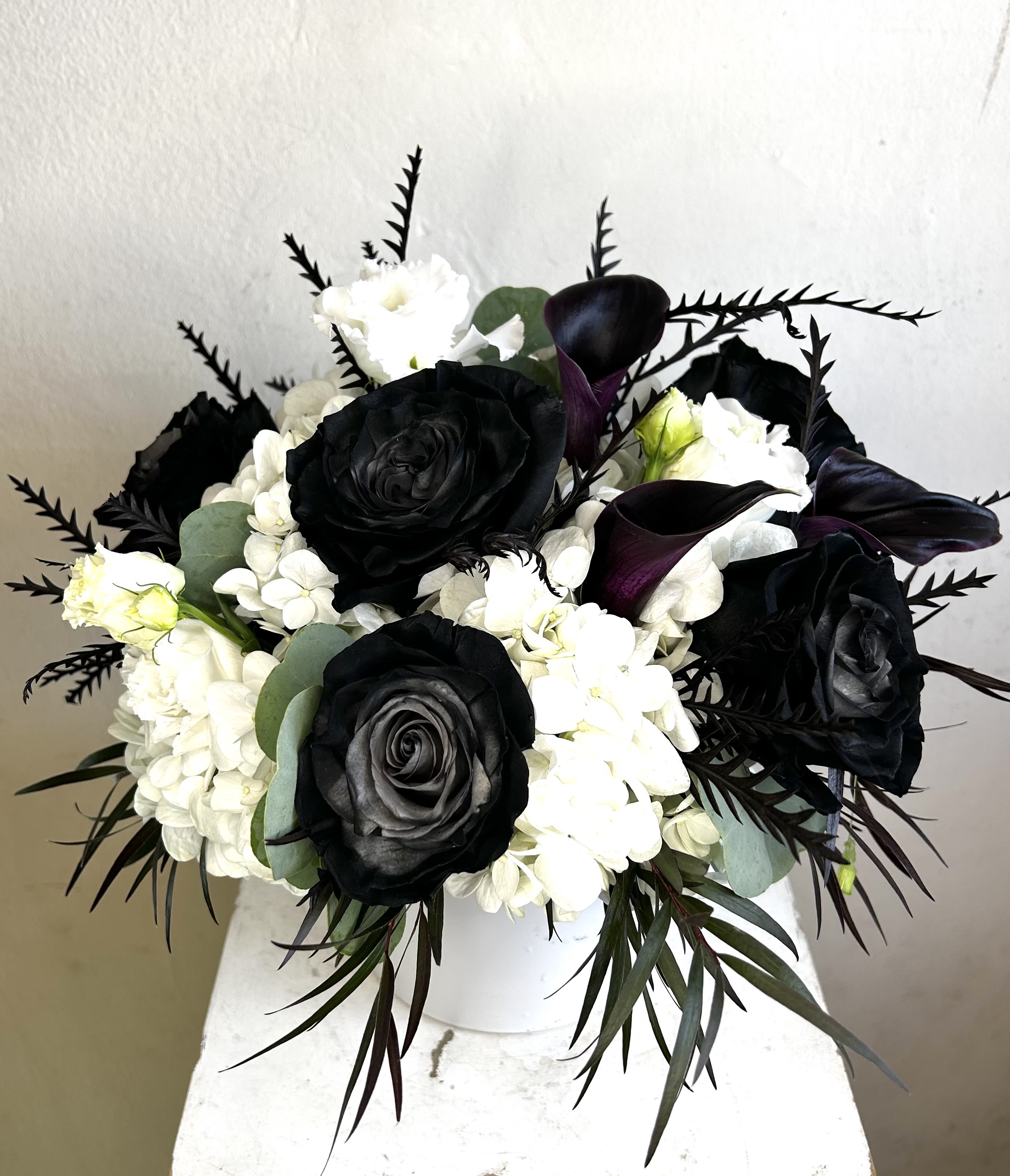 Black and white floral arrangement in a white vase