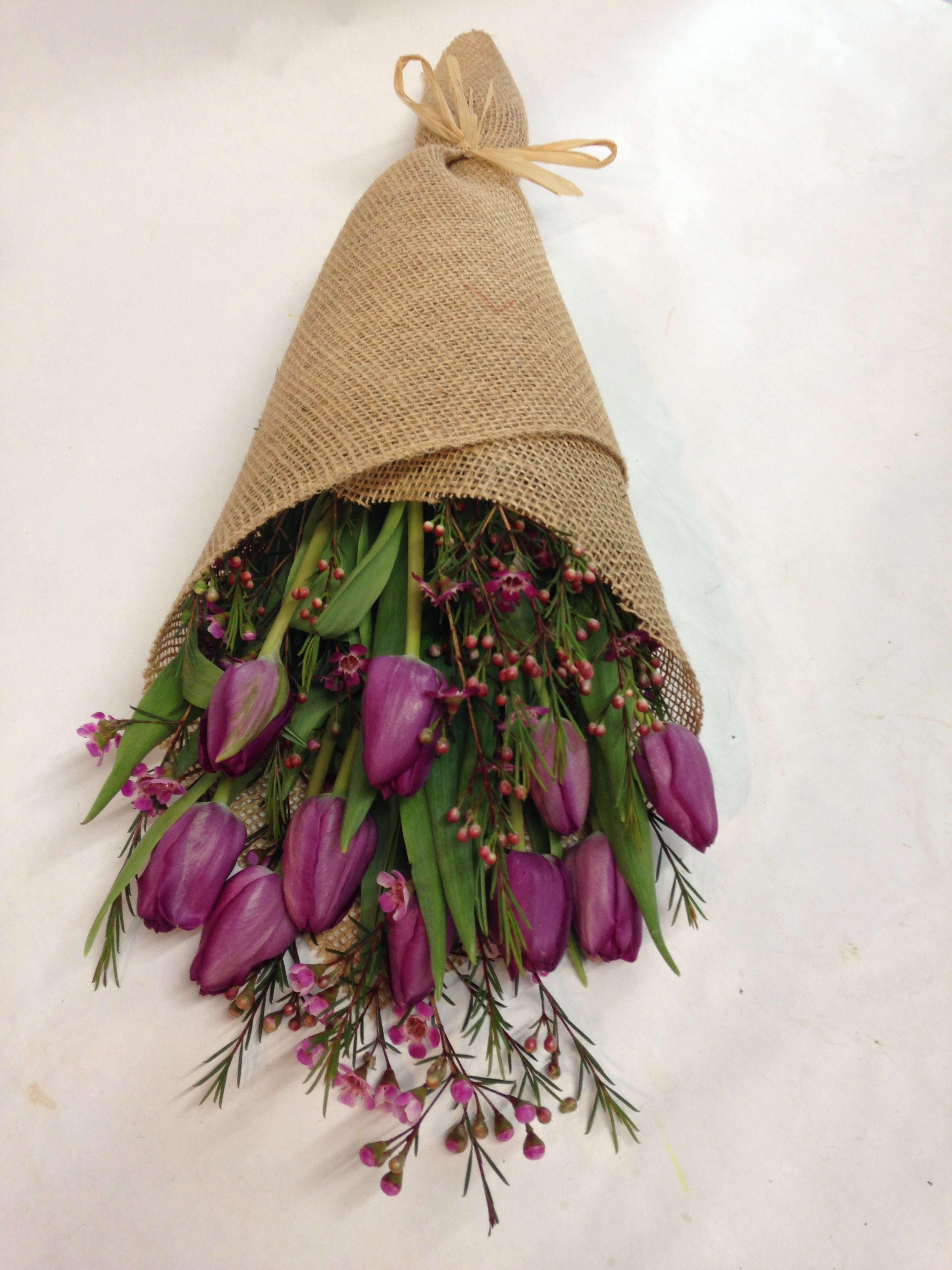 Fields of Lavender - This bunch of purple tulips is arranged with seasonal greenery and wrapped in burlap for a rustic look.  (Some flowers may be subject to change depending on the season. We will contact you with available flower substitutions; please contact us with specific questions if you are concerned with flower availability, thanks!)  FEATURED ARRANGEMENT: $48.99 (REGULAR PRICE)